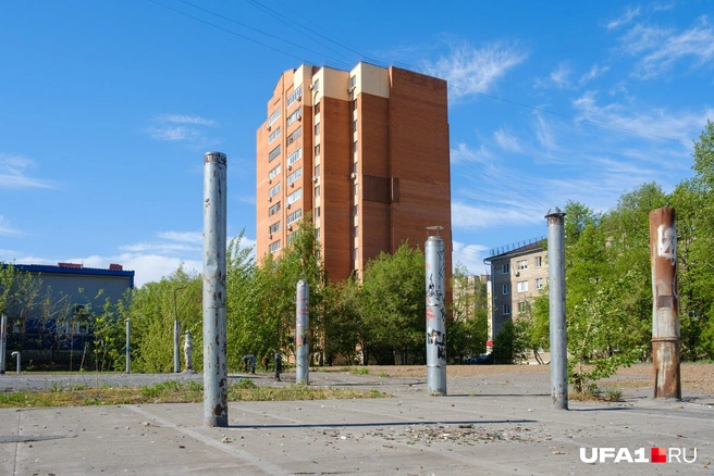 Внутри двора — металлические столбы и горы мусора, а должны были быть дома от 9 до 12 этажей