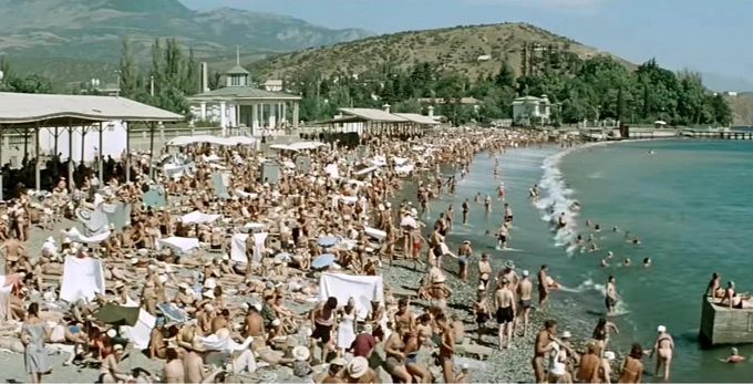 Кадр из фильма и вид на пляж Алушты. В 1962 году сцену на этом пляже снимали поздней осенью&nbsp;— в глаза бросается, что в воду отважилось зайти всего несколько актеров массовки | Источник: YouTube