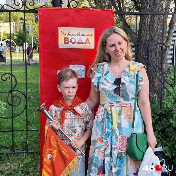 Участники праздника фотографируются в пионерской атрибутике на фоне советского аппарата с газированной водой | Источник: Александр Лисихин