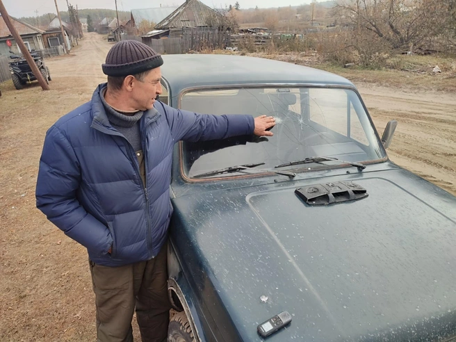 Владимир Арендаренко показывает, куда прилетели два камня за одну поездку | Источник: Илья Калинин / NGS.RU