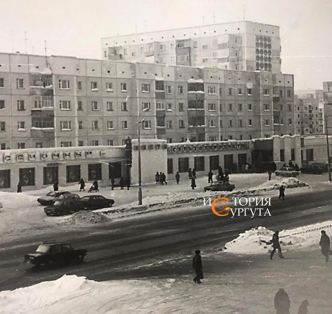 На этом фото проспект Ленина можно узнать без труда. В 80-е годы в пристройке к жилым домам размещались комиссионка и сельхозпродукты | Источник: «История Сургута / Ретро Сургут» / Vk.com