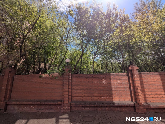 Частично забор — каменный. Возле него непростой дом с непростыми жильцами | Источник: Александр Ибрагимов / NGS24.RU