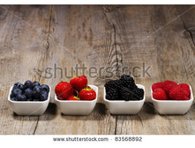 Stock-photo-row-of-wild-berries-in-bowls-on-wooden-background-83568892.jpg